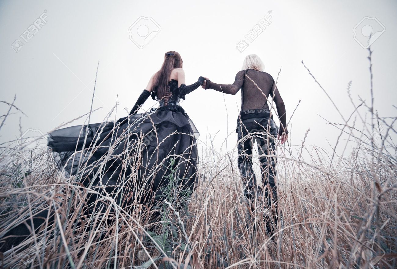 7677858-young-goth-couple-walking-on-field-bright-white-colors